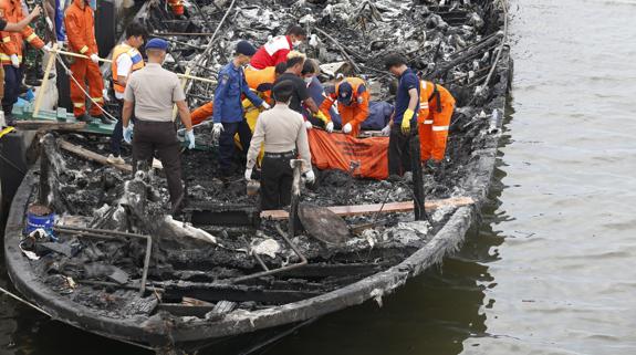 Miembros de los Servicios de Rescate indonesios recuperan los cadáveres de las víctimas del incendio.