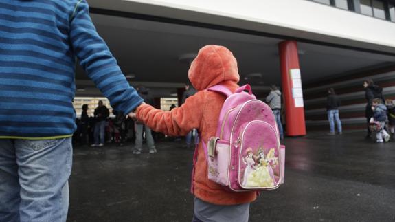 Una niña entra a su colegio. 