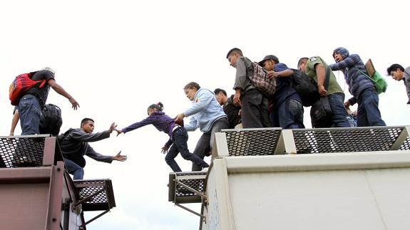 Varios migrantes tratan de pasar de un vagón a otro en 'Borderland'. 