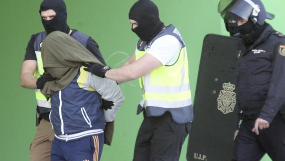 Efectivos de la Policía Nacional trasladan a un sospechoso de formar parte del Dáesh. 