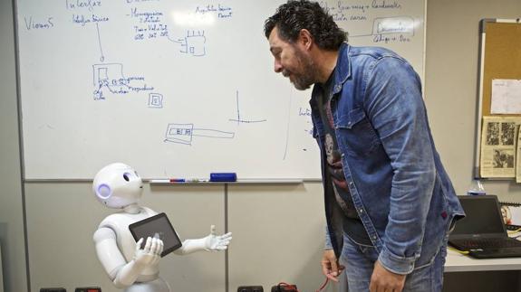 El investigador Miguel Cazorla junto al robot comercial modelo Pepper. 