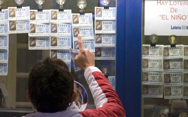Un hombre elige un décimo en una administración de lotería. 