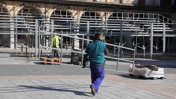 Un operario coloca las gradas en la Plaza Mayor