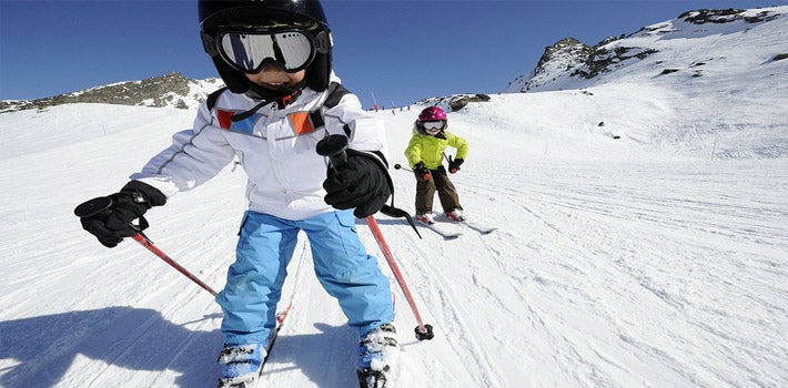 Dos niños descienden sobre una pista.