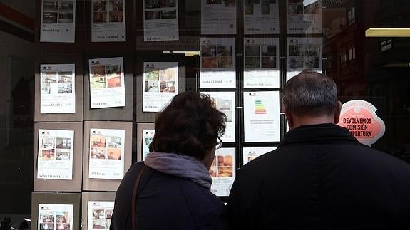 Una pareja mira los anuncios de una inmobiliaria