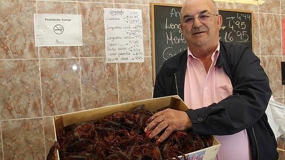 El empresario pescatero, Luis Alonso con unos cangrejos de río en una pescadería de Carrión de los Condes 
