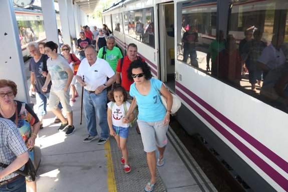 Un grupo de viajeros se bajan del tren playero procedente de León