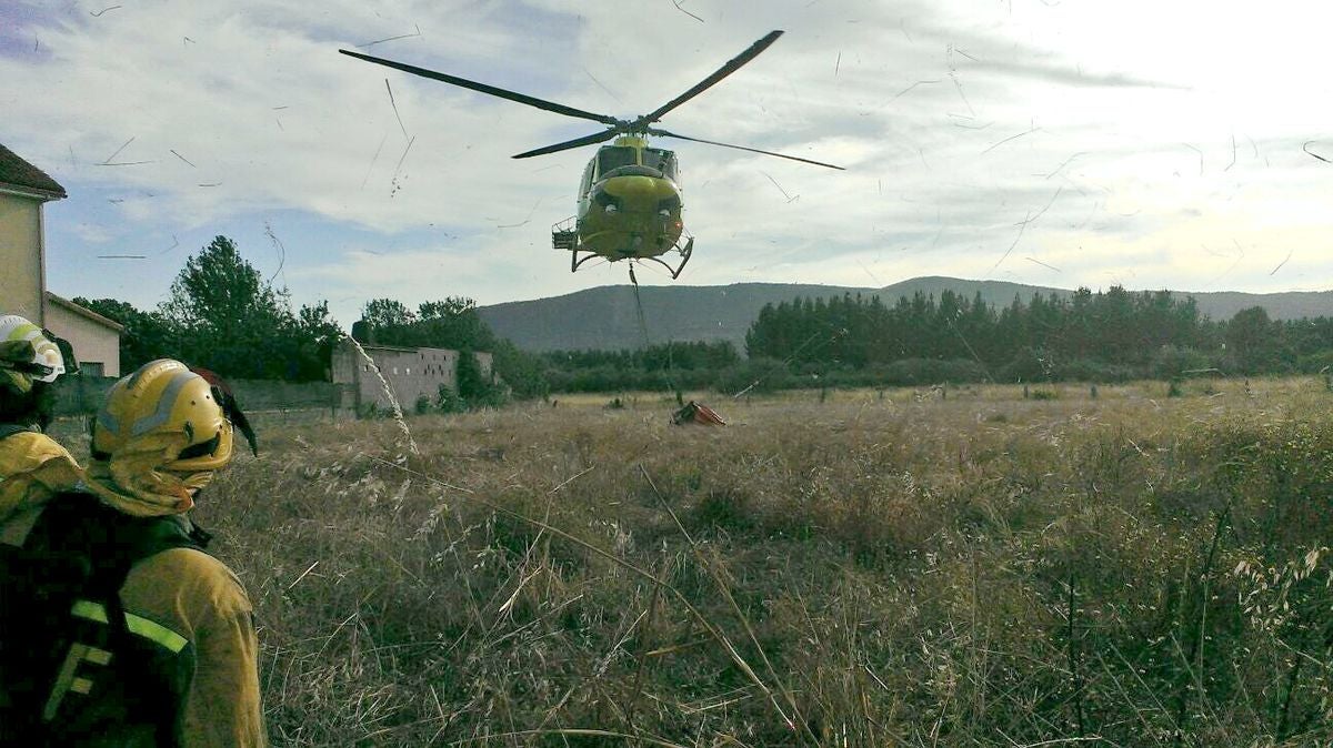 Brigadistas junto a un helicóptero.