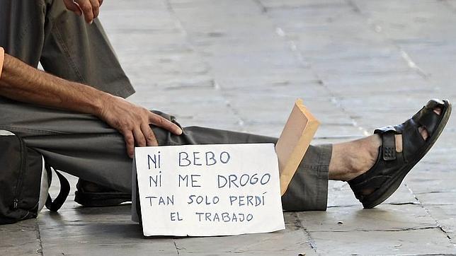 Una persona pide dinero en la calle.