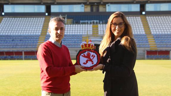 Yolanda Gil hace entrega del escudo en el Estadio Reino de León.