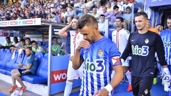 Los jugadores saltan al campo en el partido de la primera vuelta.