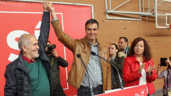 Pedro Sánchez levanta la mano de Demetrio Madrid, el sábado en León. 