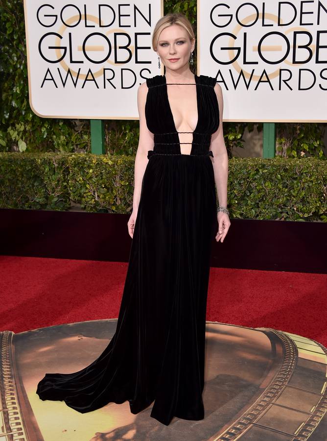 La actriz Kristen Dunst apostó por un vestido negro de atrevido escote firmado por Valentino para su paseillo por la alfombra roja de los Globos de Oro.