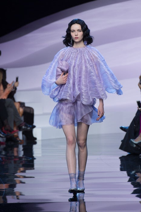 Original look con capa con volumen y minivestido vaporoso.