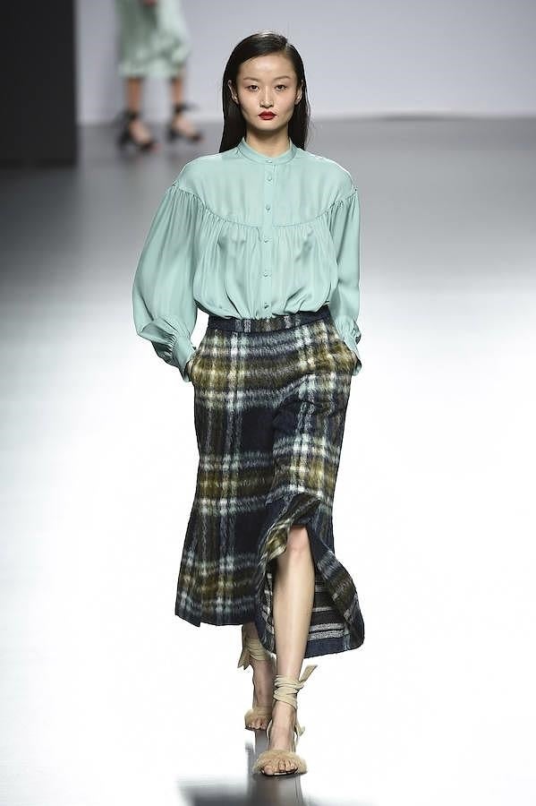 Falda asimétrica estampada en cuadros con blusa verde.