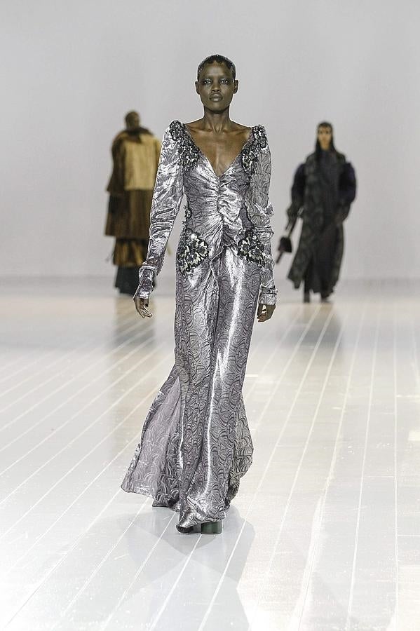 Vestido de fiesta en color gris plata hasta los pies, con cuello en pico y manga larga.