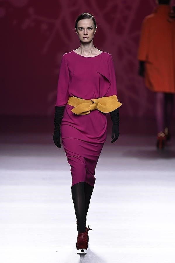Vestido fucsia con cinturón de lazo amarillo.