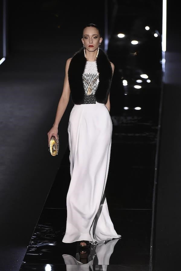 Vestido blanco con pedrería y estola de pelo negro.