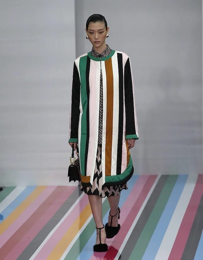 Abrigo de rayas combinado con vestido estampado.