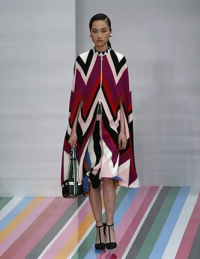 Abrigo en forma de capa con cremallera delantera y estampado geómetrico.