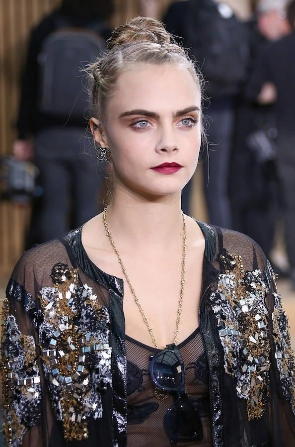 La actriz y ex modelo Cara Delevingne lució un moño de bailarina alto que adornó con tres mini trenzas de raíz en el desfile de Chanel en la Semana de la Alta Costura de París.