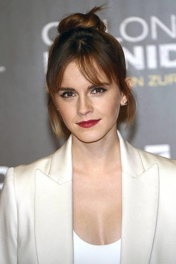 Emma Watson con moño de bailarina a la altura de la coronilla y con mechones sueltos para darle un toque informal.