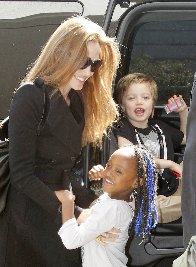 Angelina Jolie con sus hijas: Shiloh, con el pelo corto, y Zahara, con trenzas étnicas en colores.