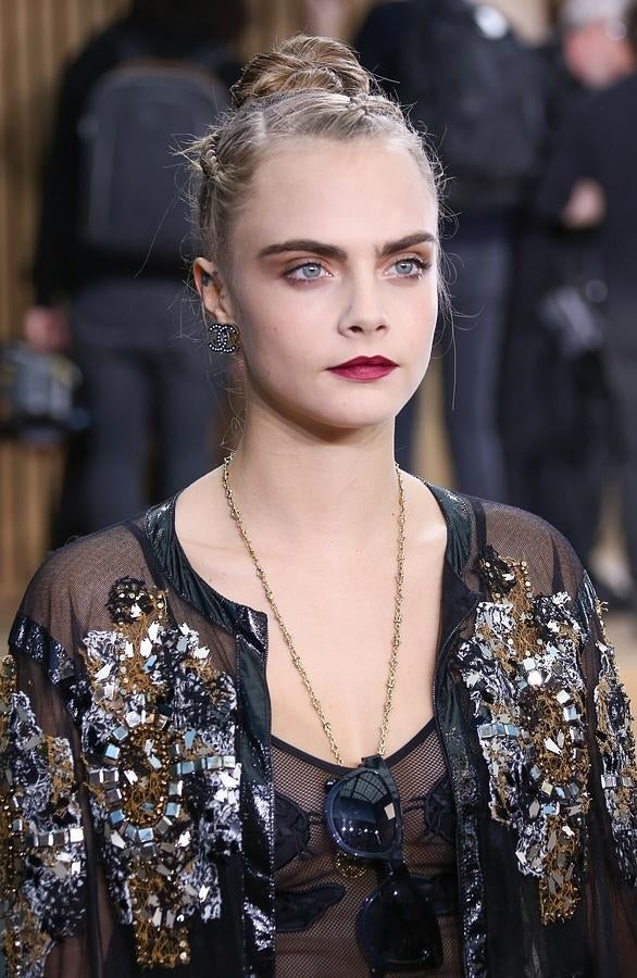 Cara Delevingne con un original recogido, muy sencillo, y también adecuado para los días de lluvia: tres mini trenzas de raíz que acaban en un moño alto.