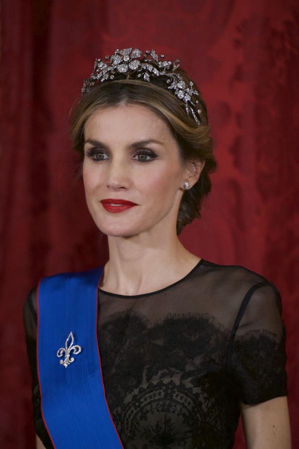 Un look clásico y solemne con un recogido bajo adornado con una tiara. Los labios rojos le aportan un toque de glamur.