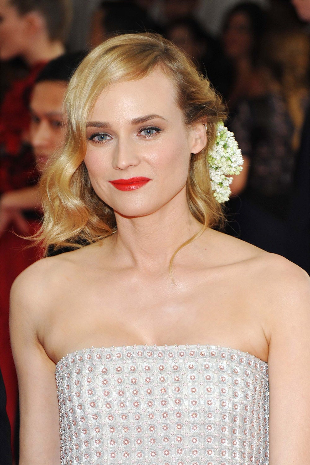 En verano las flores son una opción acertadísima para adornar el pelo. Diane Kruger luce un semirrecogido adornado con una gran flor blanca.