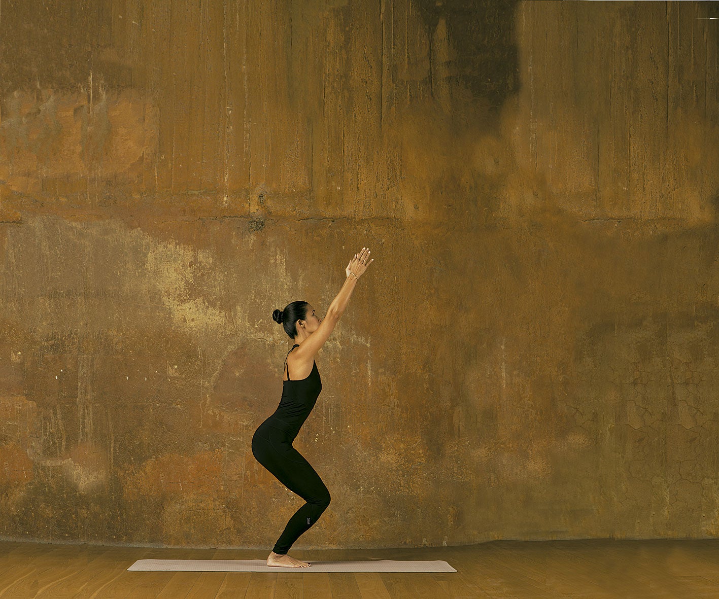 APUNTANDO AL CIELO. Desde la postura de la montaña, al inspirar, dobla las rodillas y levanta los brazos estirados, manteniéndolos cerca de las orejas sin tensar los hombros. Al espirar, lleva ligeramente el peso hacia los talones, de tal manera que puedas ver los dedos de tus pies. Mantén la postura cinco respiraciones. PALABRA DE ESXPERTA. Esta asana fortalece especialmente la columna vertebral. Además, estira los hombros y el pecho, y estimula los órganos abdominales.