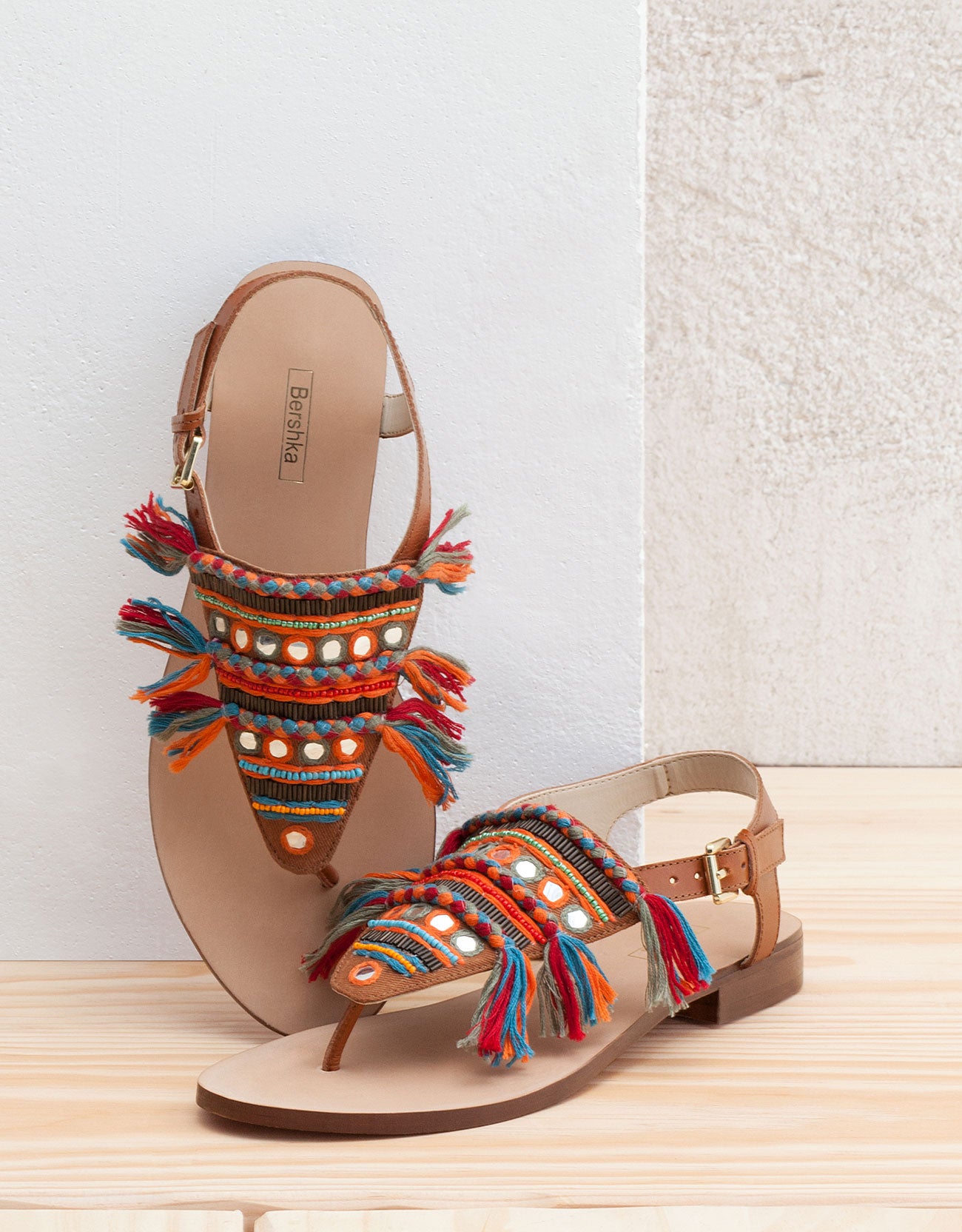 Flecos, pompones y espejos marcan gran parte de las sandalias de la temporada, como estas de Bershka (Precio rebajado de 29.99 euros a 15.99 euros).