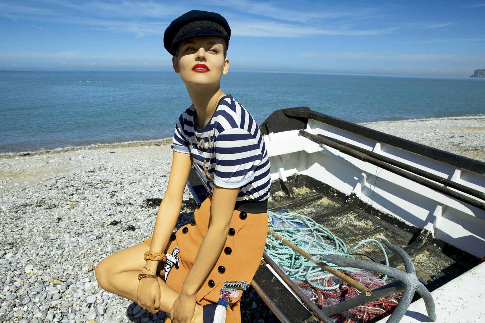 Camiseta y falda de Dolce & Gabbana y gorra de Saint James. El brazalete trenzado es de Fabien Ifires; el otro, de Zara; y la pulsera fina, de Vanessa Bruno. Zapatillas de Rivieras. Estilismo: Agnès Boy. Peluquería y maquillaje: Sébastien Poirier. Agradecimientos: Villa de Yport