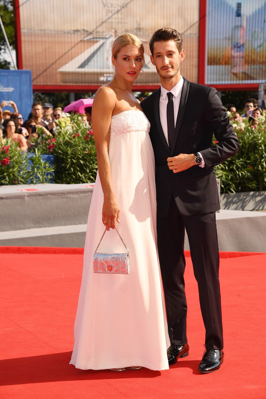 Natasha Andrews con un vestido blanco impiluto acompañada de Pierre Niney.