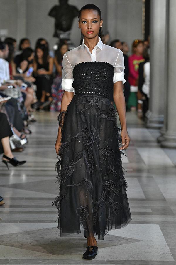 Sobre blusa de manga corta en color blanco, vestido negro con plumas