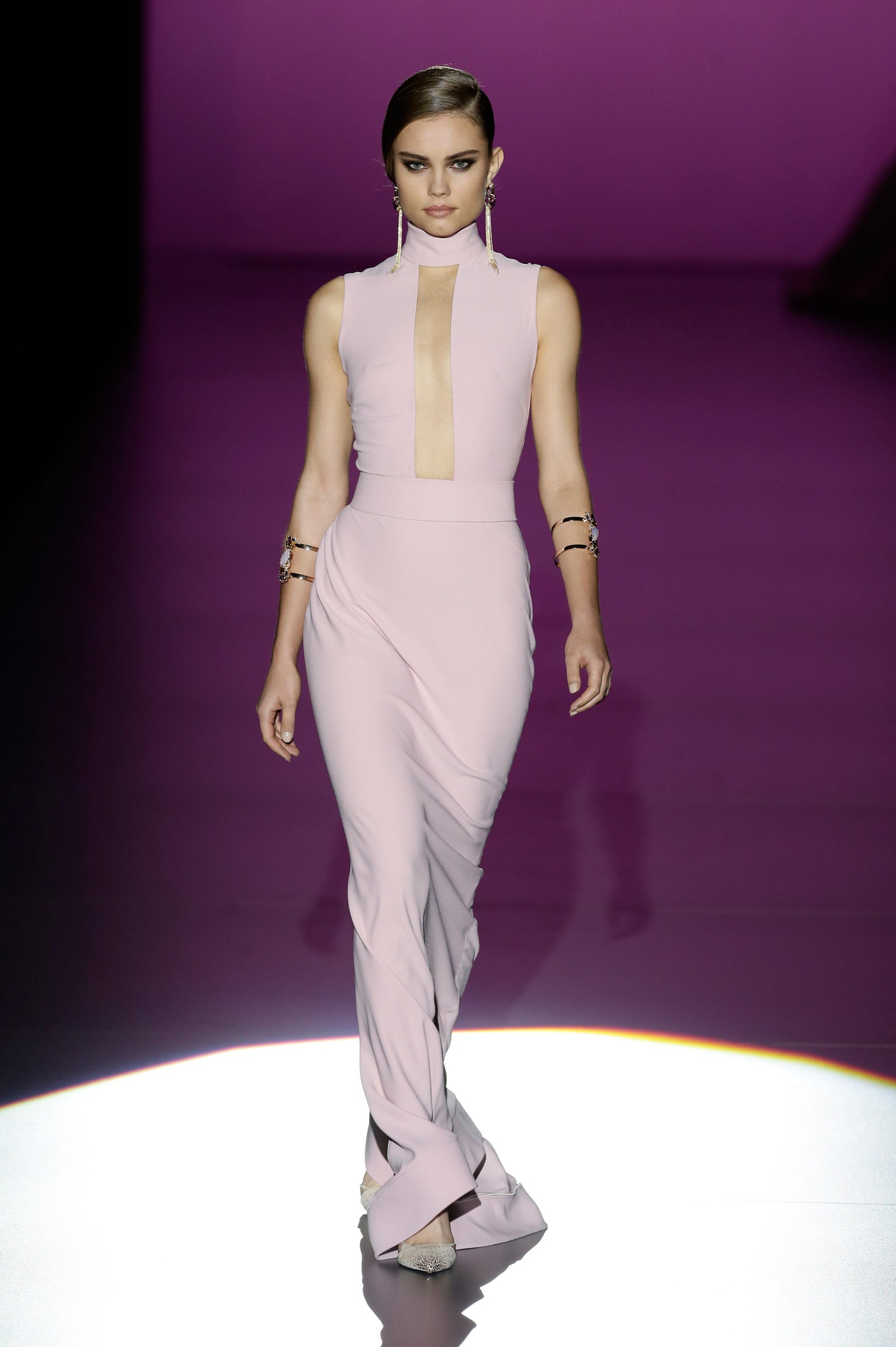 Un vestido entallado con maxi escote conjuntado con brazaletes y pendientes en dorado.