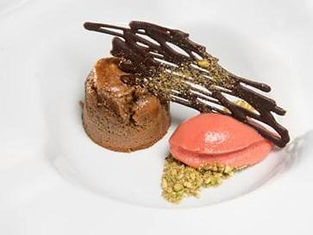 Coulant de pistachos, helado de frambuesas y teja de cacao.