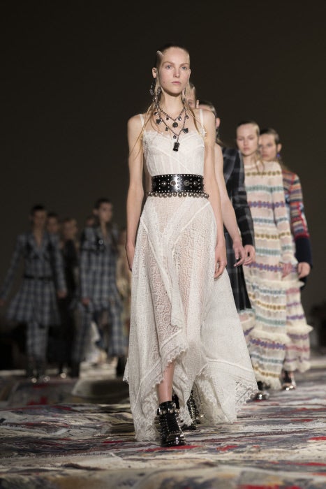 La delicadeza de este vestido blanco con transparencias juega a los opuestos con los complementos de cuero y metal con los que lo combina Sarah Burton.