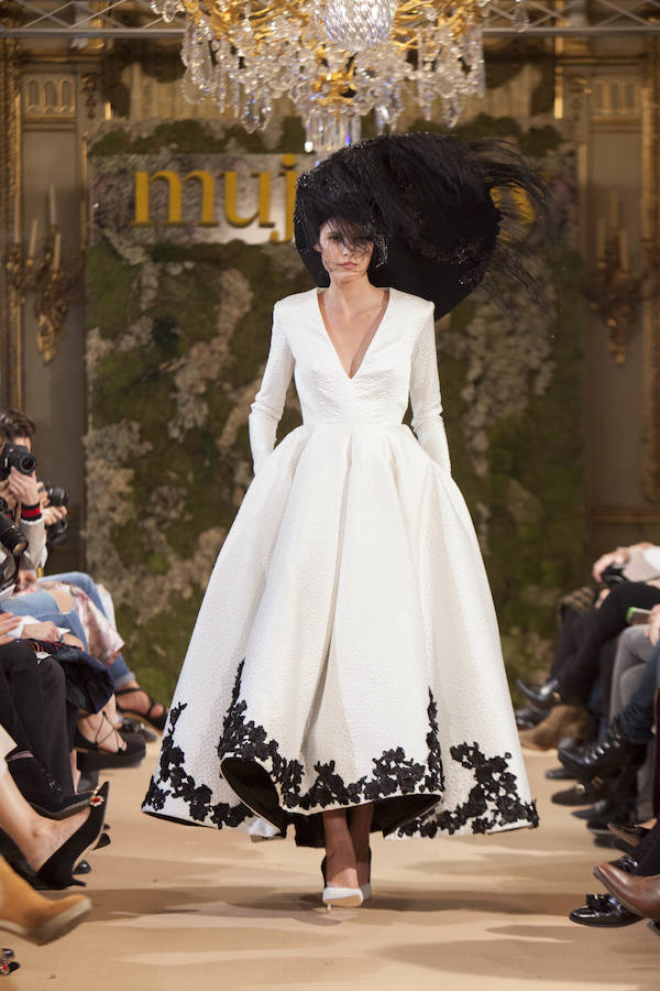 El último modelo que persentó Isabel Zapardiez en Novias Couture: vestido blanco con bordados en color negro, y como complemento gran pamela con plumas en color negro.
