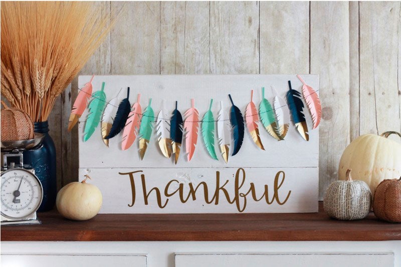 Decoración con plumas de papeles de colores pintadas con dorado.