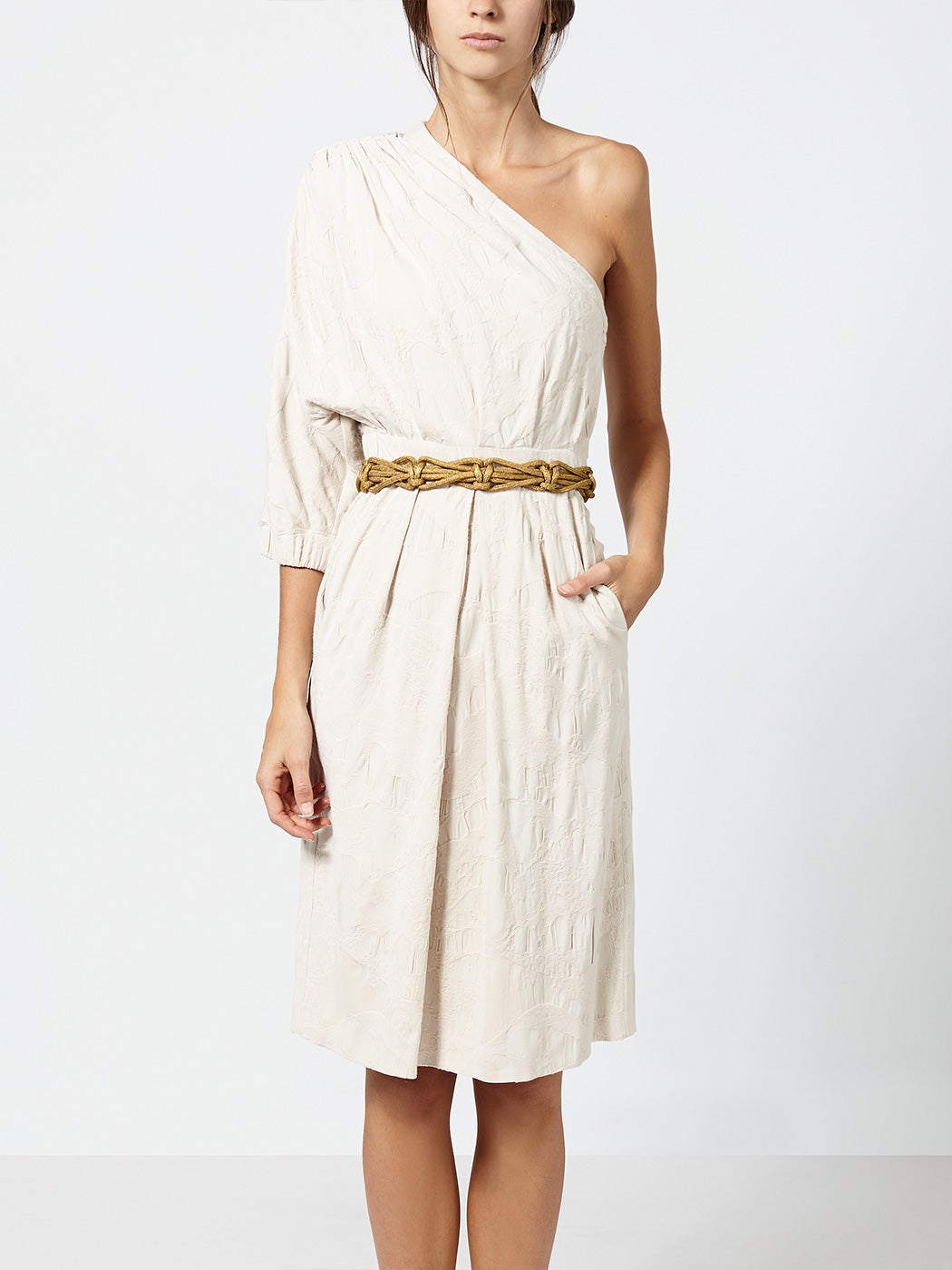 Nos encanta este vestido de escote asimétrico para una novia de día en el campo (¡o a la orilla del mar!). Combínalo con una corona de flores en tonos tierra o dorados (como el cinturón) y un ramo tipo bouquet. (174 euros)