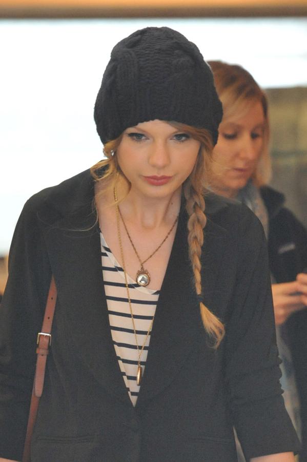 Taylor Swift, puro glamour, con este peinado con gorro: trenza lateral y mechones sueltos estratégicamente colocados a ambos lados de la cabeza.