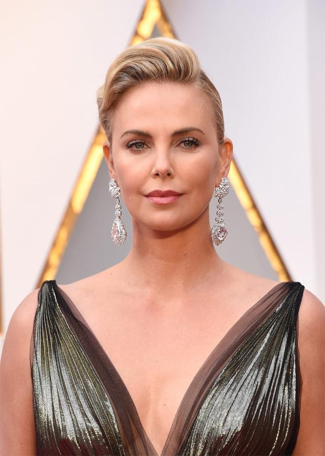 La actriz Charlize Theron lució coleta con tupé y un sencillo maquillaje con labios rosas y máscara de pestañas.