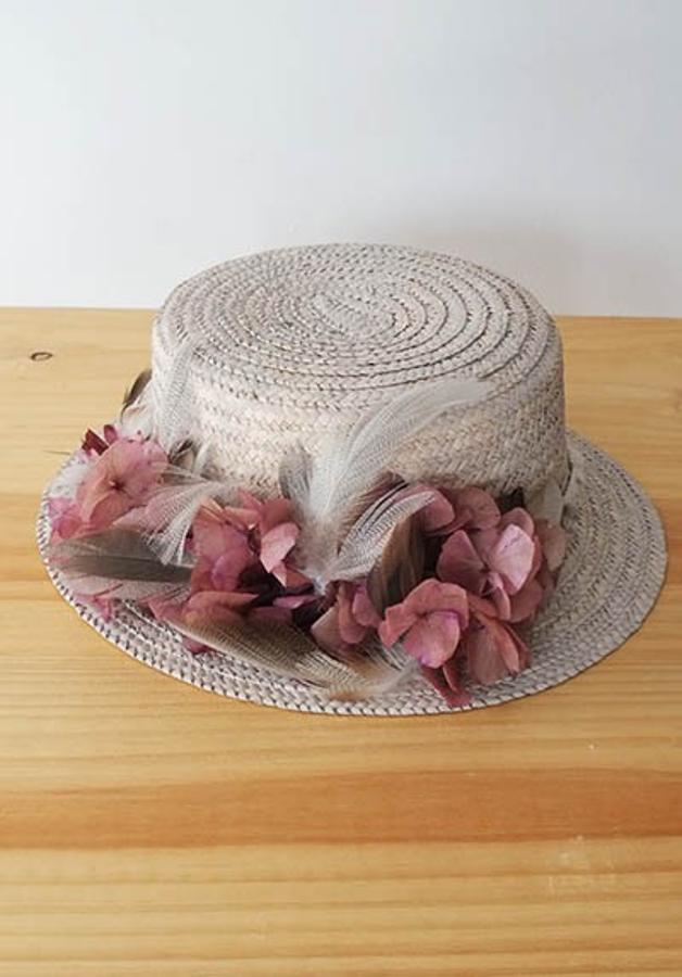 Canotier con plumas y flores secas de Cuculia. Precio: 97 euros.