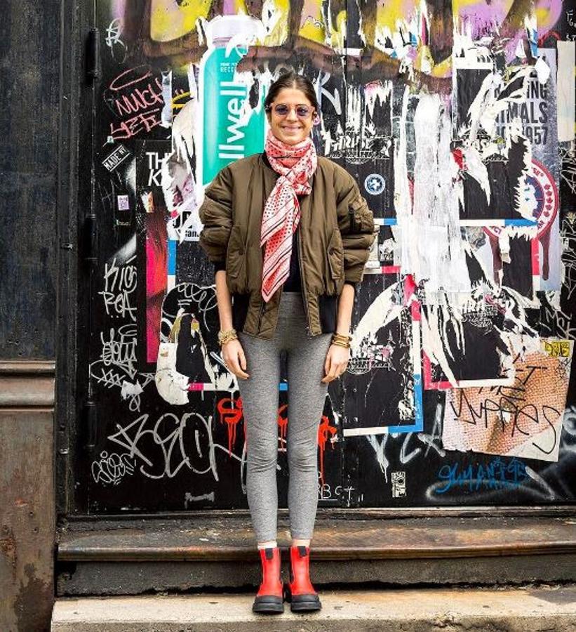 La it girl Leandra Medine apostó por un pañuelo estampado en clave maxique llevó con un look relajado con skinny jeans, bomber y botas de agua.