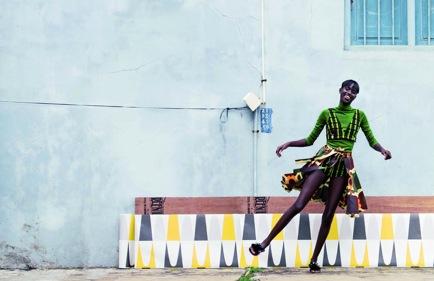 Top, suéter y falda de Miu Miu. En el suelo, papel pintado de 4 Murs.