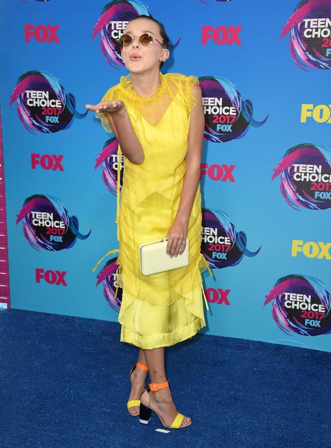 Millie Bobby Brown con vestido de Kenzo, zapatos de Pierre Hardy, bolso de Judith Leiber y gafas y joyas de Chrome Hearts.