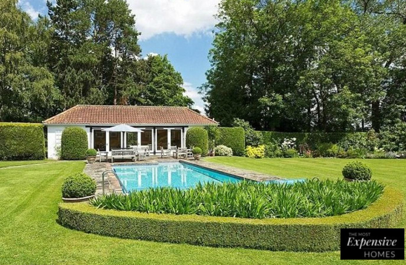 Una espectacular piscina domina uno de los espacios exteriores de esta casona medieval en Inglaterra.