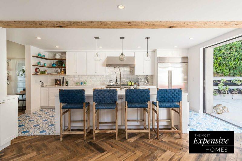 Nos encanta el contraste que se consigue con el suelo en forma de mosaico de la cocina abierta y la impresionante madera del resto de la casa.