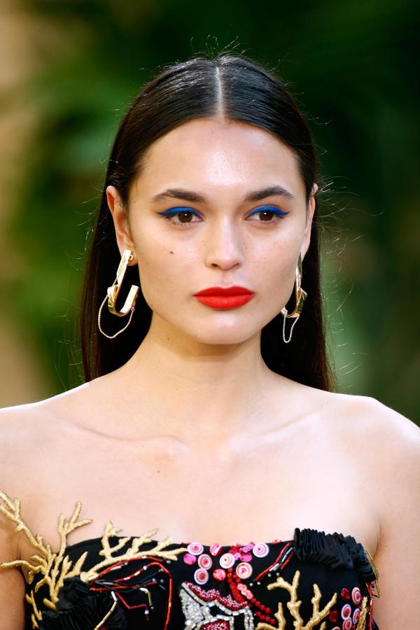 Delinear tus ojos de azul eléctrico, iluminará más tu mirada. Lograrás un maquillaje a la última si te pintas los labios de un color naranja llamativo.